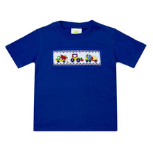 Load image into Gallery viewer, The Construction Smocked Play Tee is perfect for little ones who love to play with construction vehicles. This royal blue tee features a detailed smocked design of a construction vehicle on the front, making it both fun and stylish. Pair it with our Blue Striped Seersucker Leo Shorts for a complete look for toddler boys.
