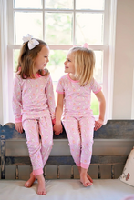 Load image into Gallery viewer, Get ready for a spooky night in with our James and Lottie Girls Two-Piece Long Sleeve Pajamas! Made with soft pink fabric, these pajamas feature a cute ghost and pumpkin design. Perfect for snuggling up and staying cozy on those cool fall nights. Order yours now for the ultimate fall sleepover.
