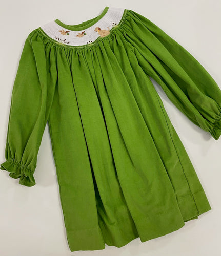 Get ready for cuteness overload with our Ducks and Dog Corduroy Smocked Dress! Made for toddler girls, this classic green corduroy dress features a playful smocked design with flying ducks and dog details. With a fun wildlife motif around the neckline, your little one will look adorable and stylish.