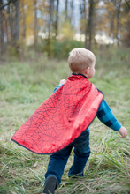 Load image into Gallery viewer, Every hero needs a cape! The Colour-A-Cape Spider Superhero is the perfect addition to your crime-fighter&#39;s wardrobe. Save the day or defeat monsters in the backyard with personalized style and flair! Includes 6 markers. This cape is also reversible with a red spider printed satin on the other side.
